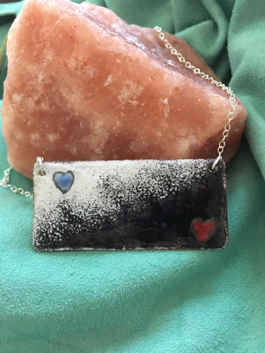 Harlequin Black and White enamel pendant with red and blue hearts
